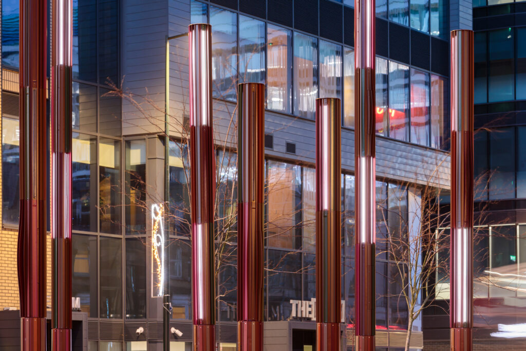 bespoke lighting columns with integrated speaker system on the street, designed for immersive lighting experience